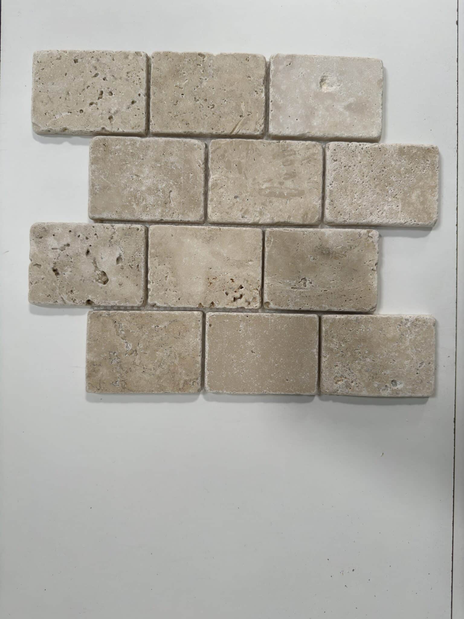 Mosaïque en travertin blanc ivoire vieilli composée de rectangles (7,3 x 10 cm) posés en quinconce, AL-590, fond gris, vue de travers