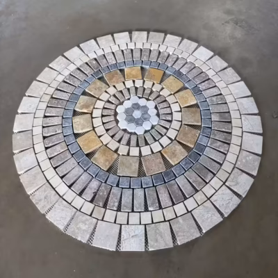Rosace en marbre et travertin, AL-2440, composée de carrés, de rectangles et d'hexagones de différentes tailles et couleurs (vue de biais sur fond gris).